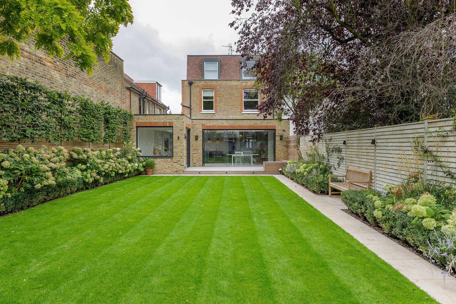 Newly landscaped UK garden with striped lawn and paving