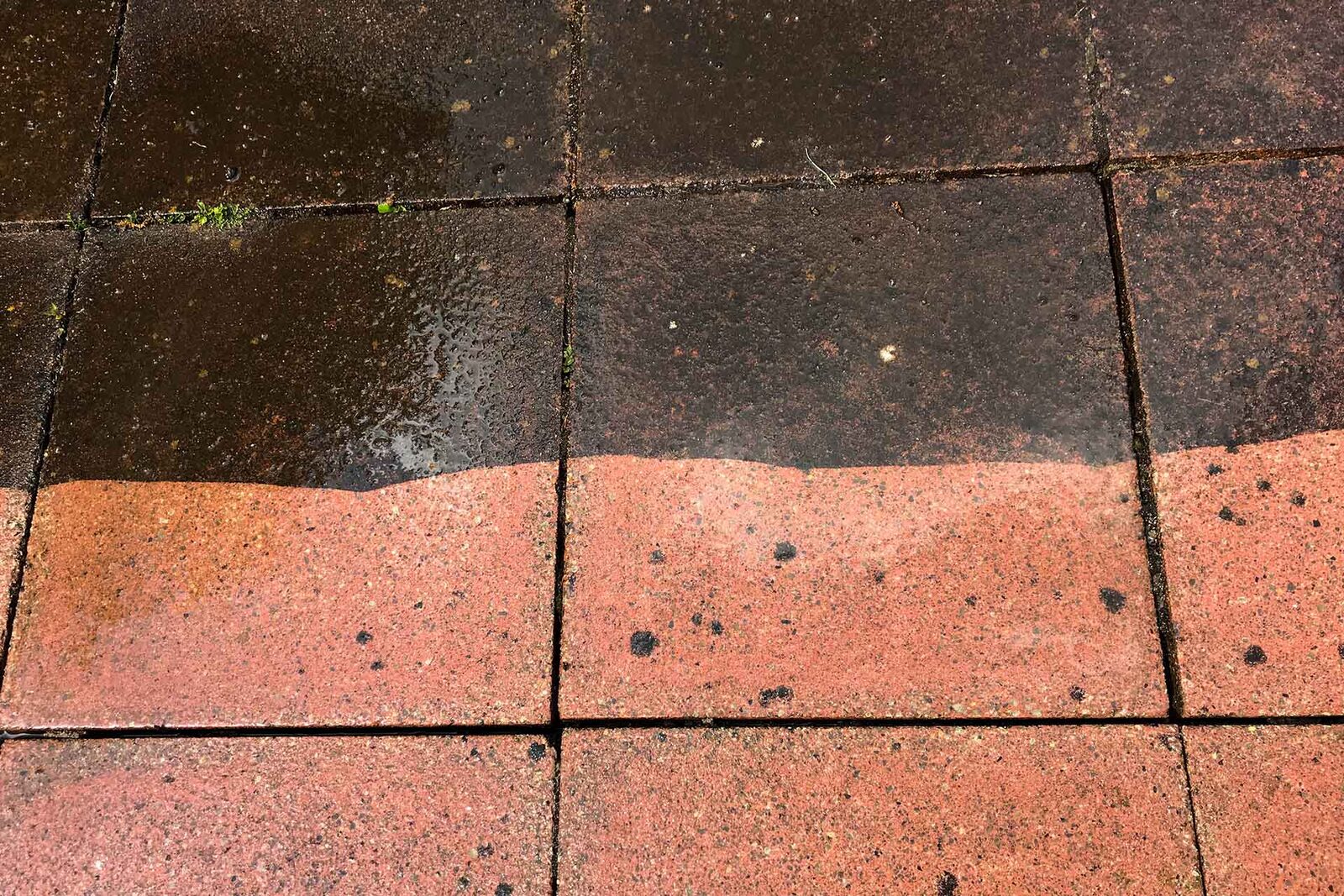 Patio slabs half cleaned by a pressure washer